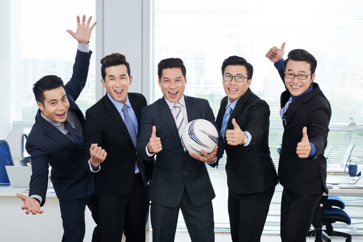supportive sales team at office holding world cup football