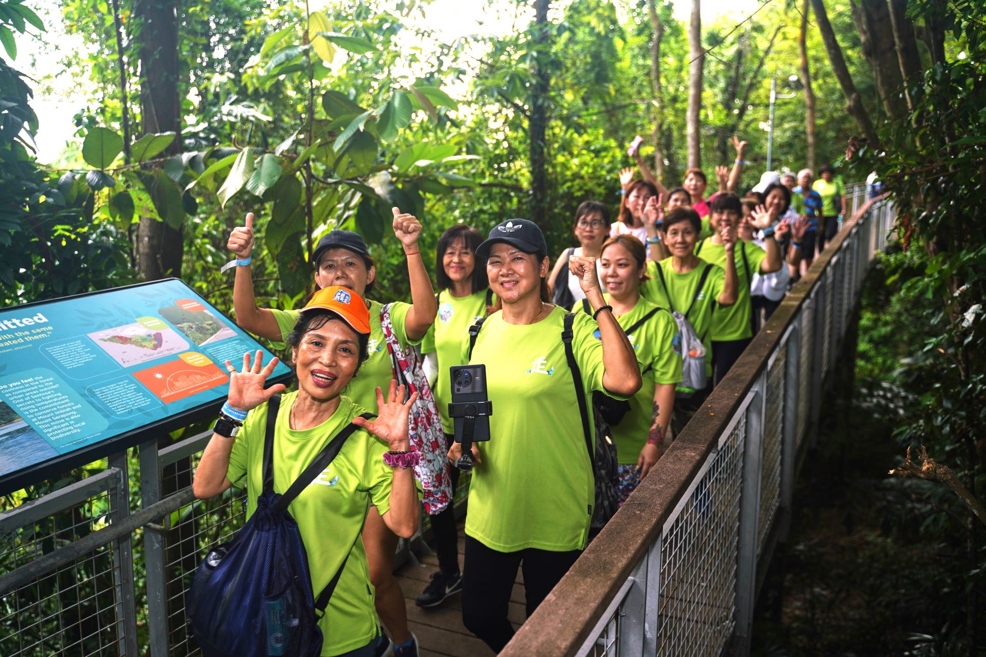 老朋友趴趴走 PaPaZao participants smiling and waving at the camera on their walk at Sentosa Island, Singapore.