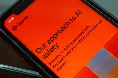 Smartphone screen displaying OpenAI's approach to AI safety, related to cyber security threat awareness.