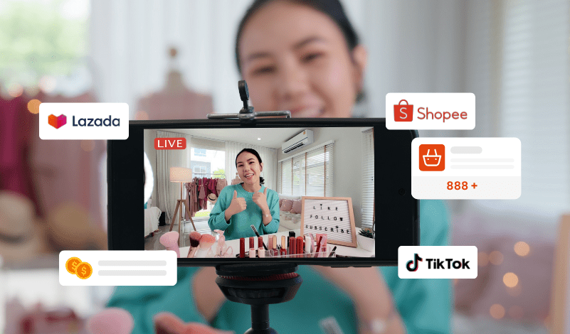 On-screen graphics indicate that the live session is being broadcasted on popular e-commerce platforms Lazada and Shopee, as well as the social media platform TikTok, with live viewer interactions shown by the 'like' and 'shopping cart' icons.