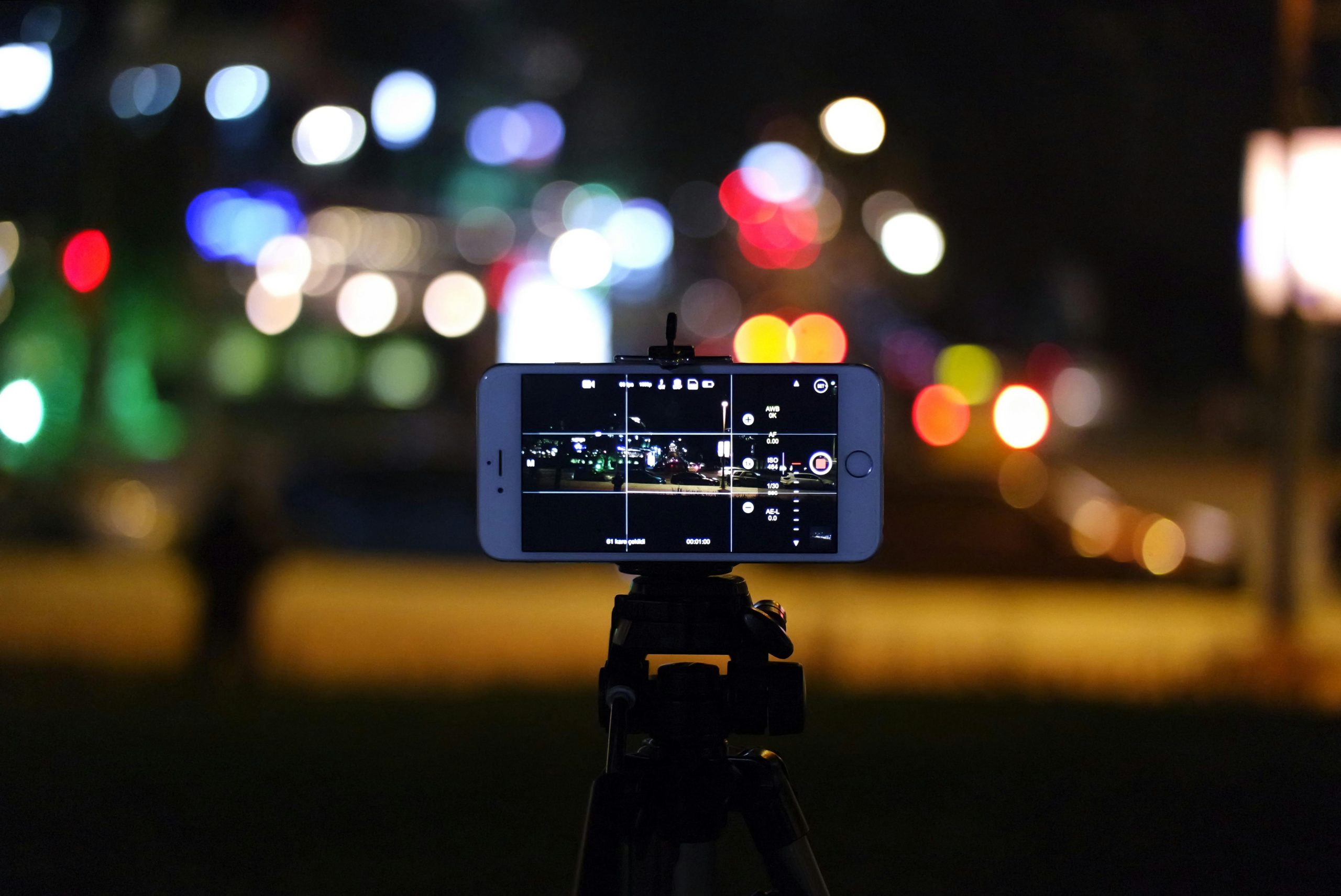 Smartphone mounted on a tripod capturing a night scene.