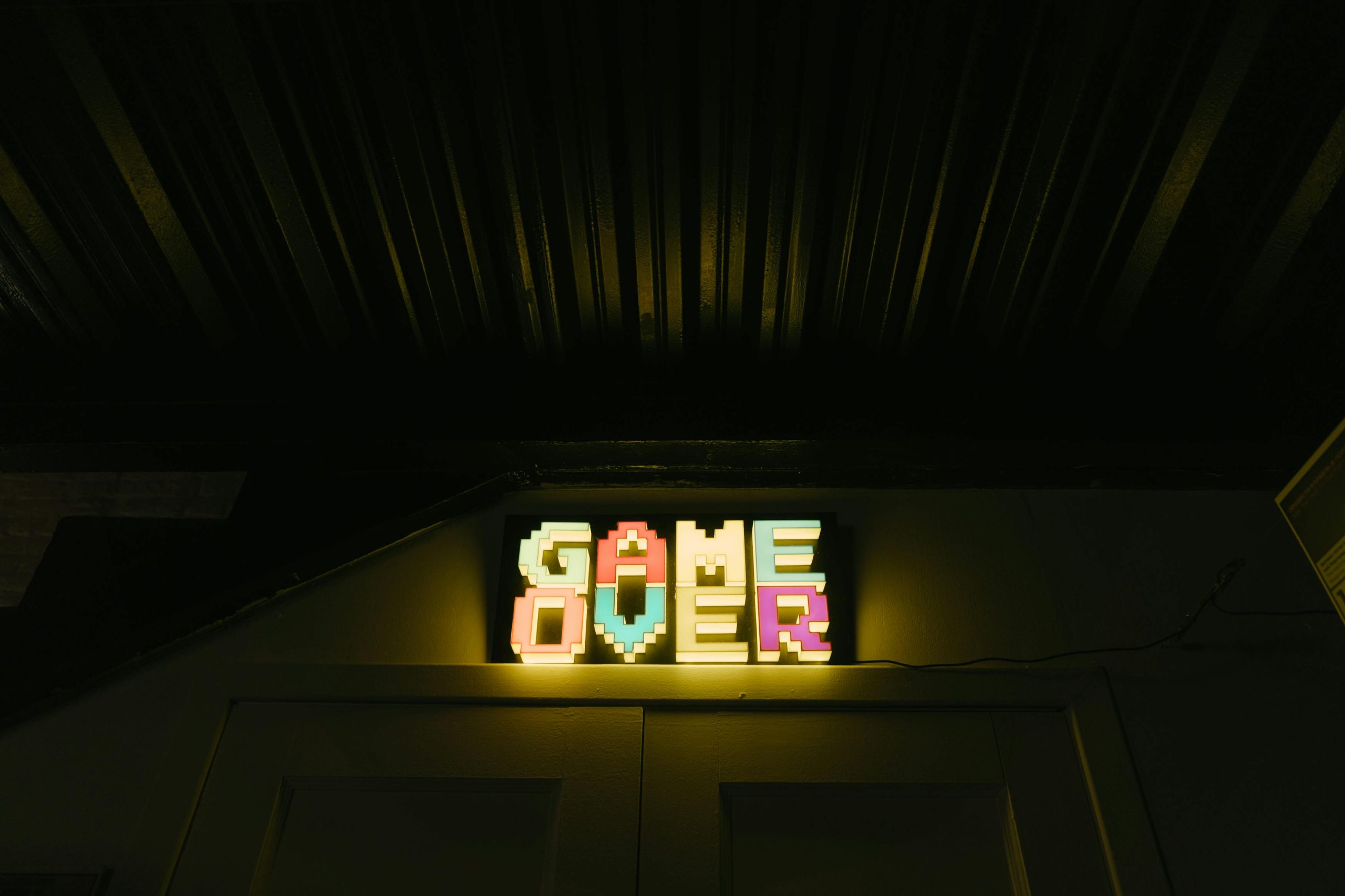 A neon sign with pixelated letters spelling out "GAME OVER," symbolising an end or completion.